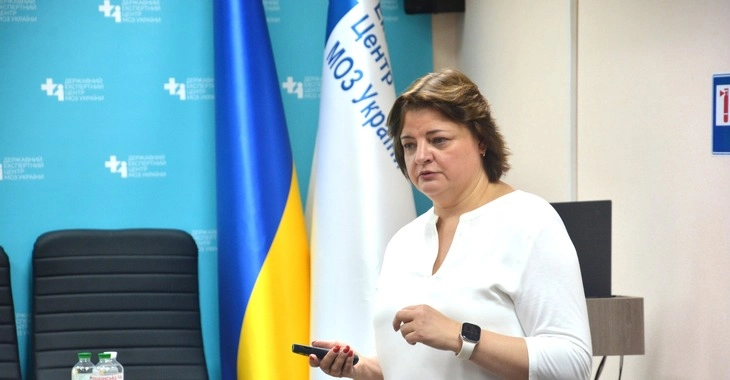 Жінка проводить презентацію на семінарі в Центрі, на тлі прапор України та логотипи МОЗ України