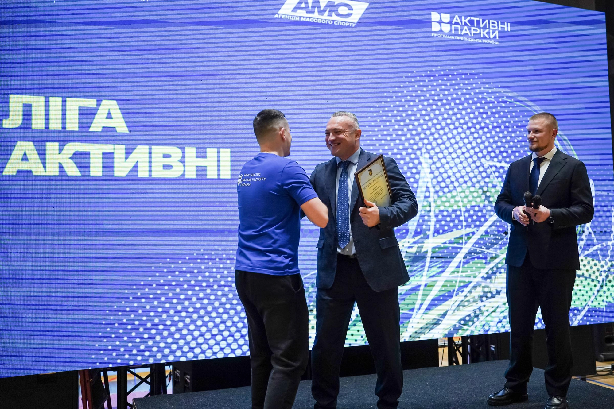 Сергій Тимофєєв нагороджує переможця шкільної ліги з шахів на сцені під час заходу у Львові