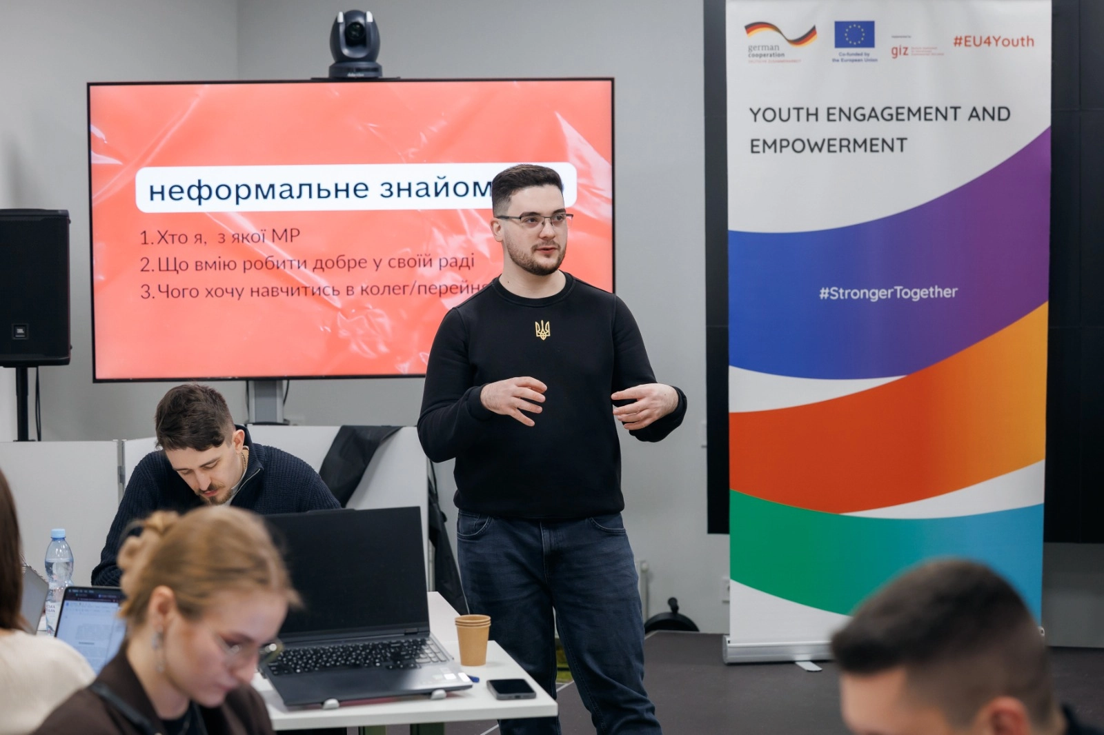 Чоловік виступає перед групою людей на фасилітованій зустрічі молодіжних рад у Києві